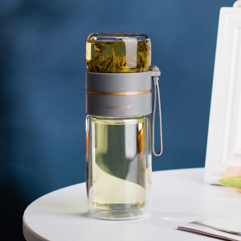 The Glass Tea Bottle next to a hot beverage, emphasizing its heat-resistant design and functionality.