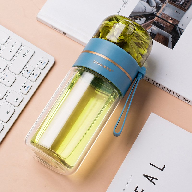 Hand holding the Glass Tea Bottle with Infuser, showing its comfortable grip and portable size.